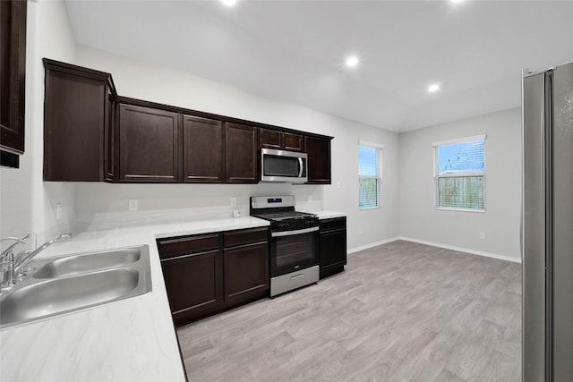 kitchen featuring dark brown cabinetry, sink, stainless steel appliances, and light wood-type flooring