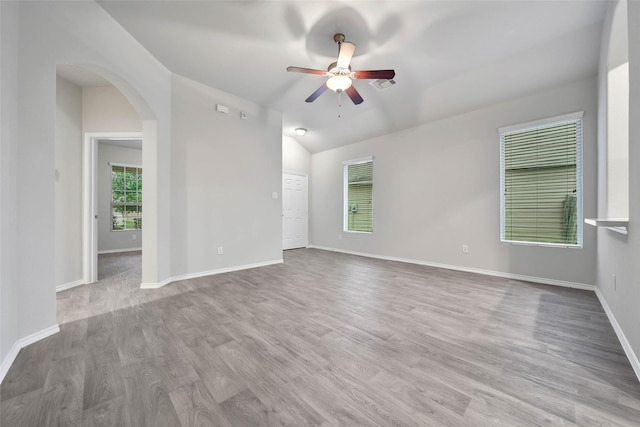 spare room featuring ceiling fan, lofted ceiling, and light hardwood / wood-style flooring