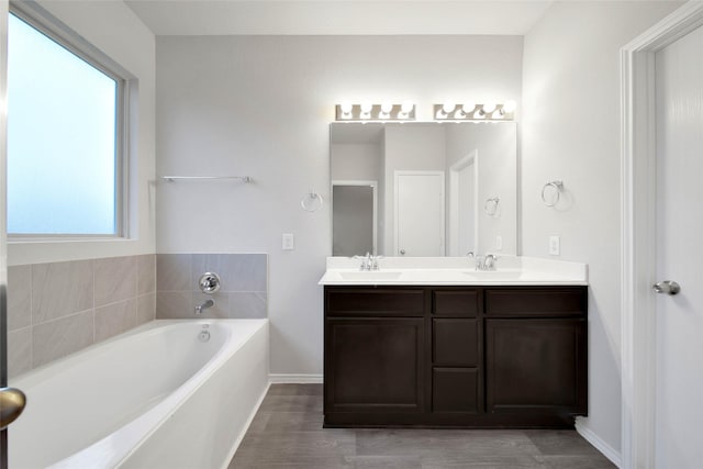 bathroom with vanity, hardwood / wood-style flooring, and a tub