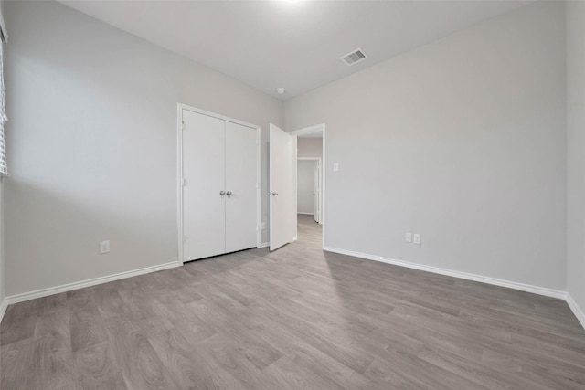 unfurnished bedroom featuring a closet and light hardwood / wood-style floors