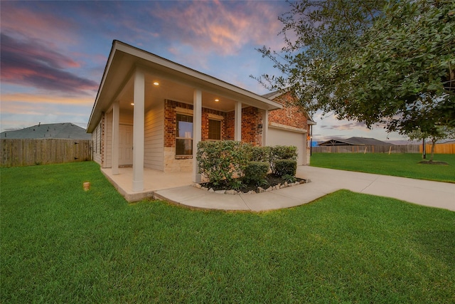 property exterior at dusk featuring a yard and a garage