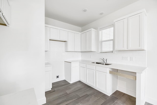 kitchen featuring white cabinets, backsplash, and sink