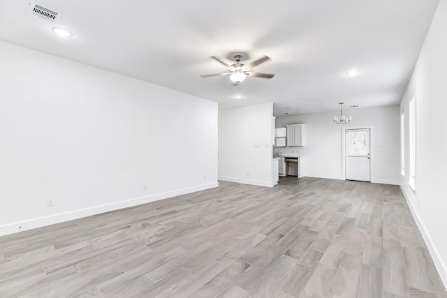 unfurnished living room with light hardwood / wood-style flooring and ceiling fan with notable chandelier