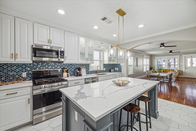 kitchen featuring white cabinets, decorative light fixtures, ceiling fan, and appliances with stainless steel finishes