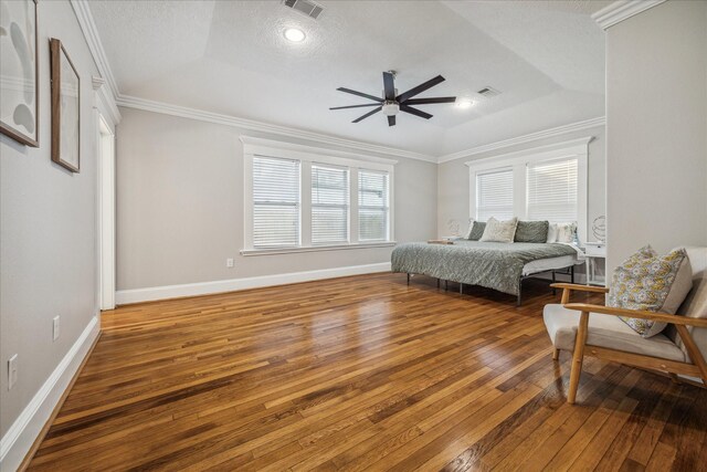 bedroom featuring a raised ceiling, ceiling fan, wood-type flooring, and ornamental molding