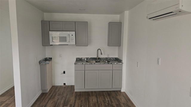 kitchen featuring a wall mounted AC, sink, gray cabinetry, and dark wood-type flooring