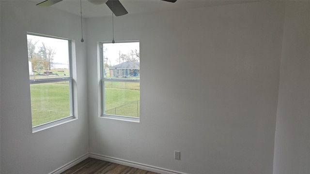 unfurnished room with ceiling fan and dark wood-type flooring