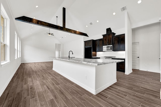 114 Little Spring Ct, Anahuac, TX 77514 - kitchen featuring stainless steel microwave, a large island, wood finished floors, range, and a ceiling fan
