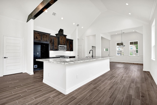 114 Little Spring Ct, Anahuac, TX 77514 - kitchen with stainless steel microwave, a sink, dark wood-type flooring, freestanding refrigerator, and high vaulted ceiling