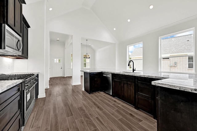 114 Little Spring Ct, Anahuac, TX 77514 - kitchen featuring a sink, stainless steel appliances, plenty of natural light, light stone counters, and high vaulted ceiling