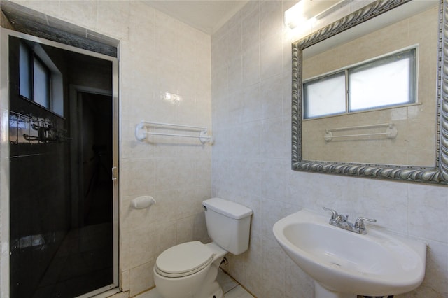 bathroom featuring toilet, sink, and tile walls