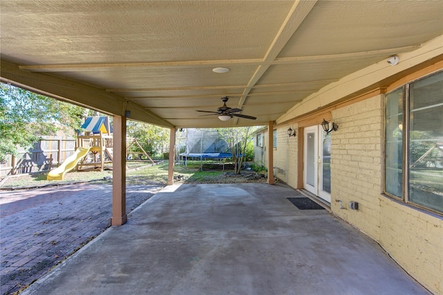 view of patio featuring ceiling fan, a trampoline, and a playground