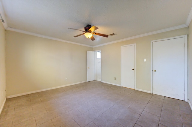 tiled empty room featuring ceiling fan, a textured ceiling, and ornamental molding