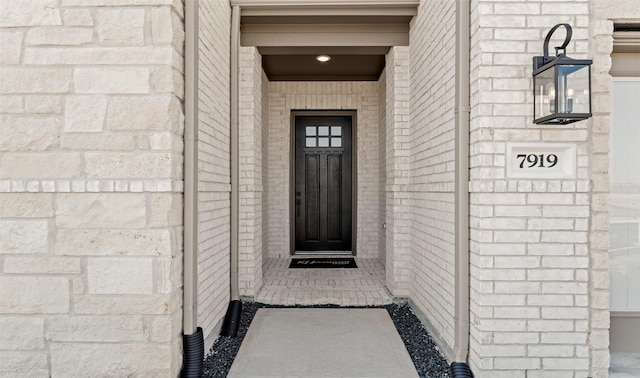 doorway to property featuring brick siding