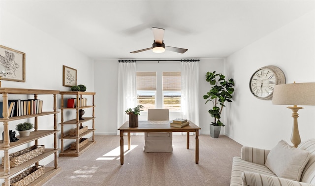 office area featuring light carpet, ceiling fan, and baseboards