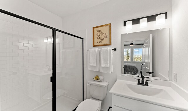 bathroom featuring toilet, a shower stall, and vanity