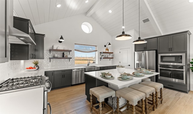 kitchen with appliances with stainless steel finishes, light countertops, light wood-style flooring, and open shelves