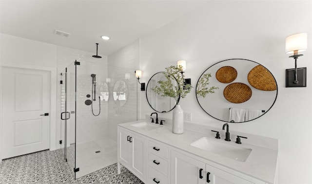 bathroom featuring a stall shower, tile patterned flooring, visible vents, and a sink