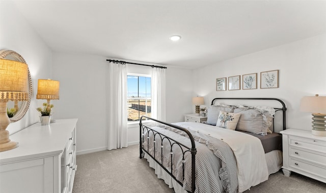 bedroom with light colored carpet and baseboards