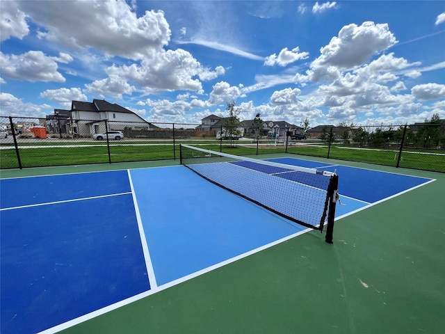 view of sport court featuring a residential view and fence