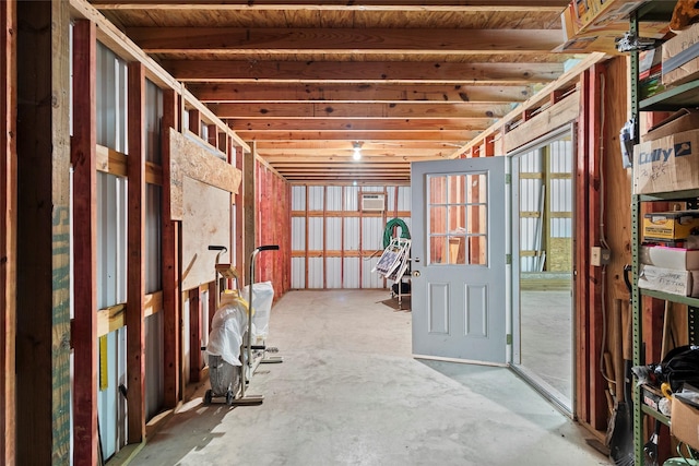 misc room with a healthy amount of sunlight, concrete flooring, and a wall mounted air conditioner