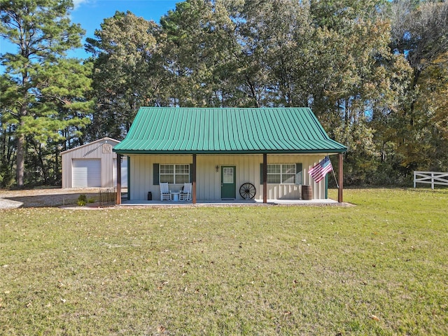 view of outbuilding featuring covered porch, a yard, and a garage