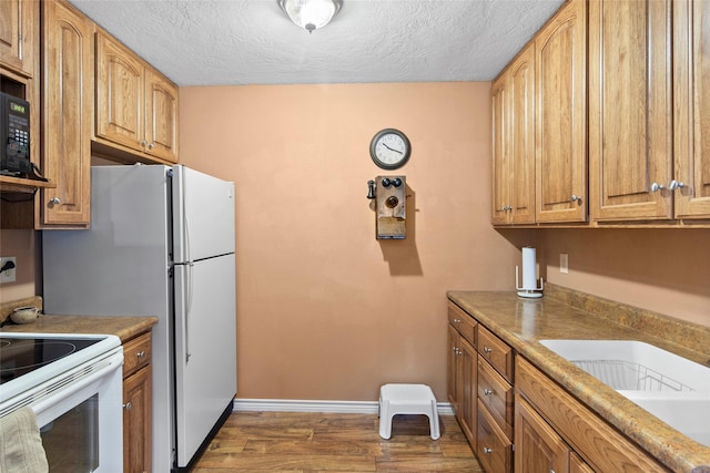 kitchen with sink, dark wood-type flooring, a textured ceiling, and white electric stove