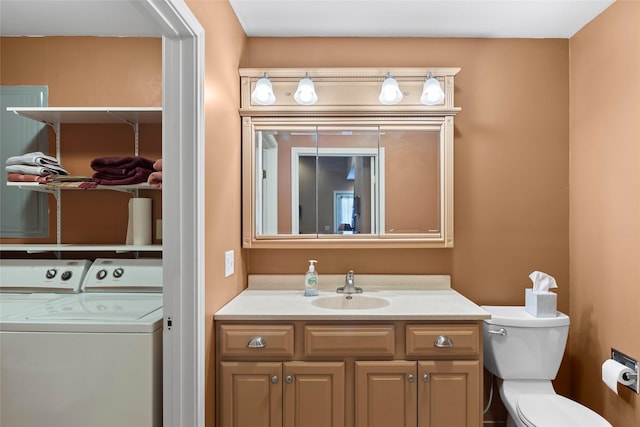 bathroom with vanity, washing machine and dryer, and toilet