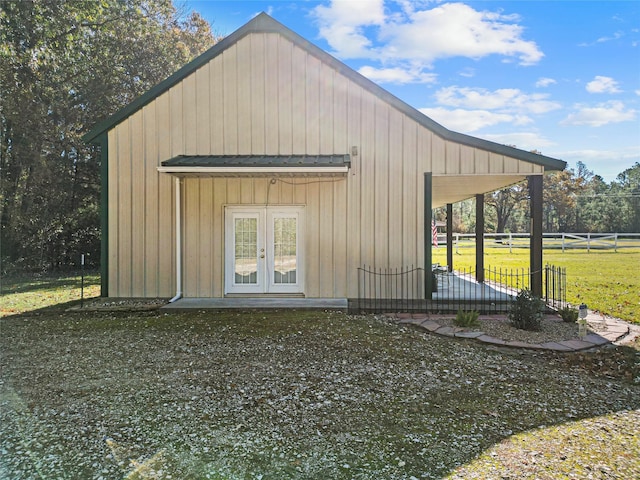 view of outdoor structure featuring a yard and french doors