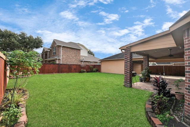 view of yard with ceiling fan and a patio