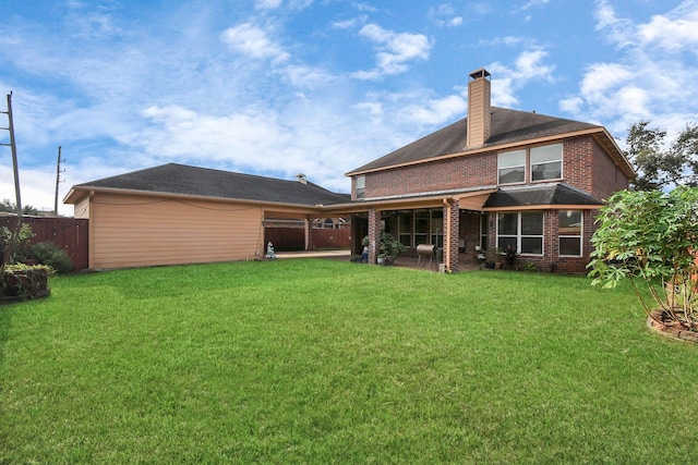 rear view of property featuring a lawn and a patio area