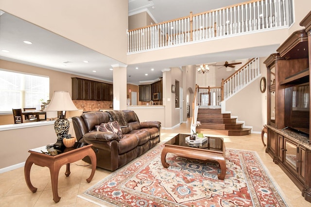 tiled living room featuring ceiling fan, crown molding, and a high ceiling