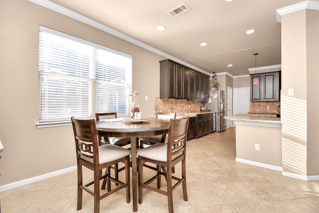 tiled dining room with plenty of natural light and ornamental molding