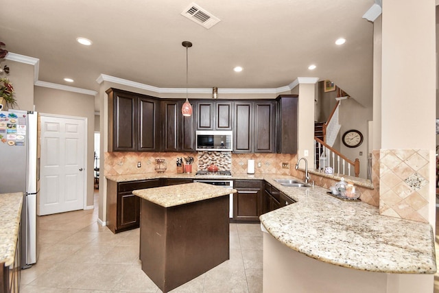 kitchen featuring kitchen peninsula, appliances with stainless steel finishes, light stone countertops, sink, and pendant lighting