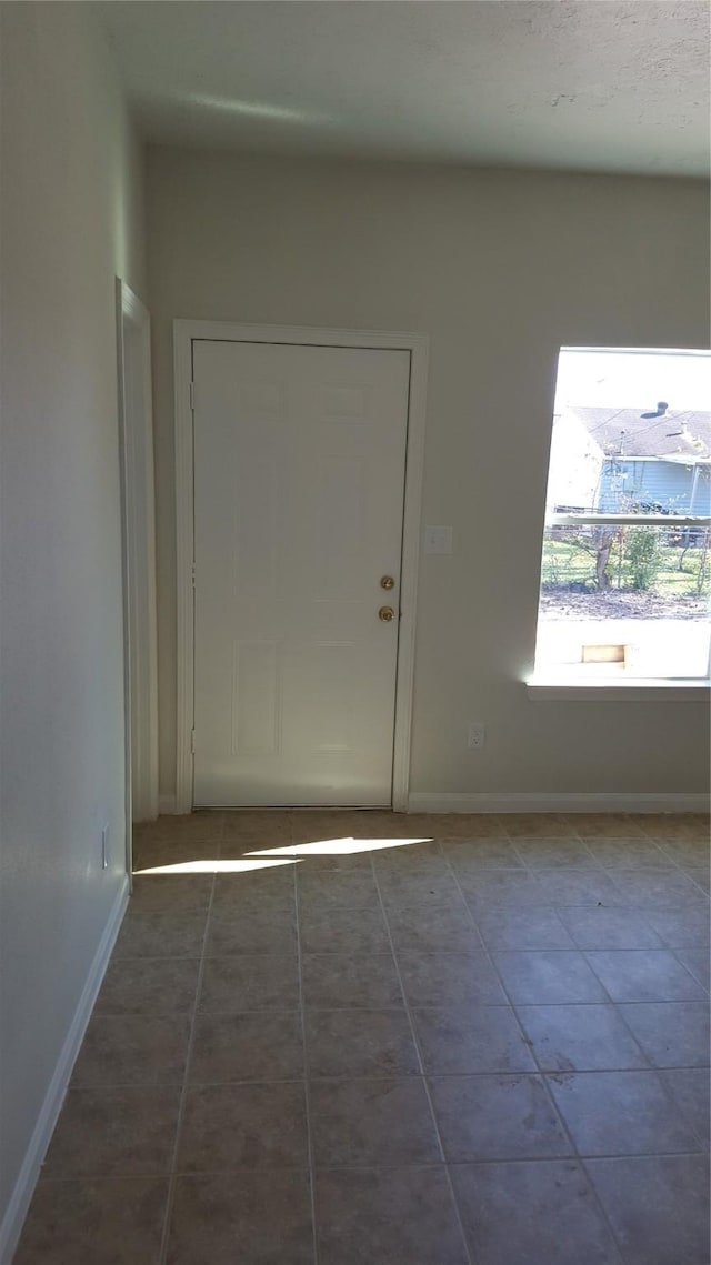 entryway with dark tile patterned flooring