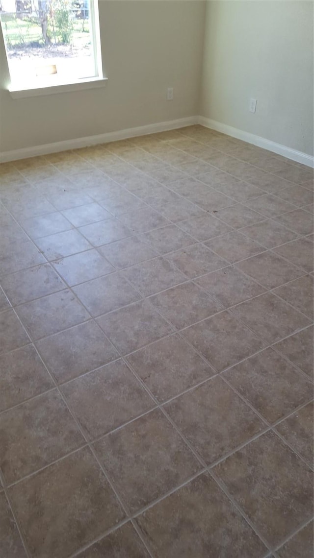 unfurnished room with dark tile patterned floors