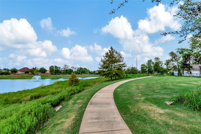 surrounding community featuring a lawn and a water view