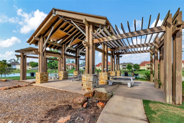 surrounding community featuring a water view and a pergola