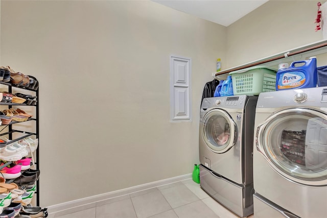 clothes washing area featuring light tile patterned floors and washer and dryer