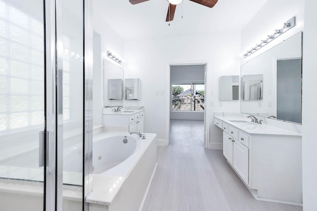 bathroom featuring hardwood / wood-style floors, ceiling fan, a tub to relax in, and vanity