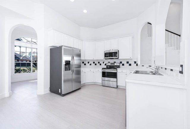 kitchen with white cabinets, sink, appliances with stainless steel finishes, and tasteful backsplash