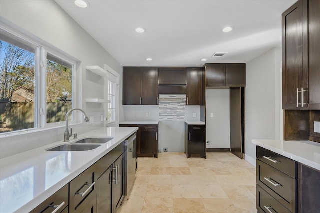 kitchen featuring dishwasher, decorative backsplash, dark brown cabinets, and sink