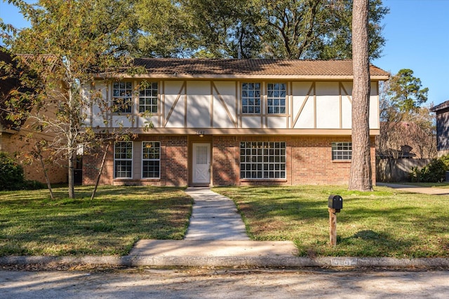 english style home featuring a front yard