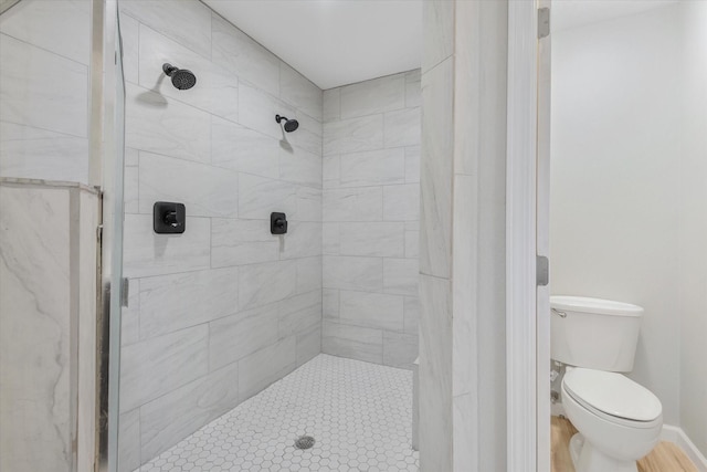 bathroom with toilet and tiled shower