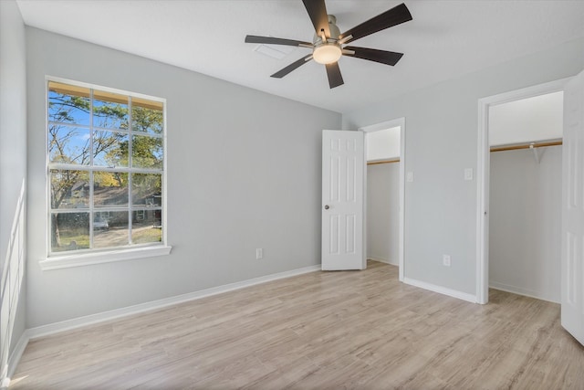 unfurnished bedroom with multiple windows, ceiling fan, and light wood-type flooring