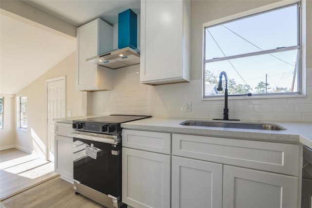 kitchen with white cabinetry, plenty of natural light, stainless steel appliances, and wall chimney range hood