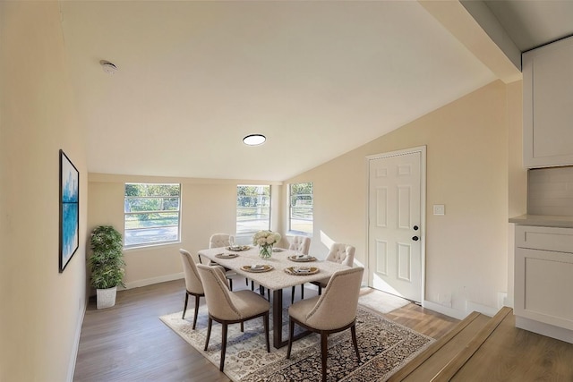 dining space with light hardwood / wood-style flooring and lofted ceiling