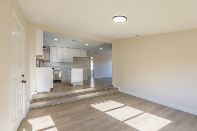 unfurnished living room with light hardwood / wood-style floors and sink