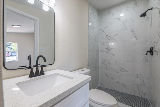 bathroom featuring tiled shower, vanity, and toilet