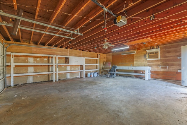 garage featuring a wall mounted AC, ceiling fan, and a garage door opener